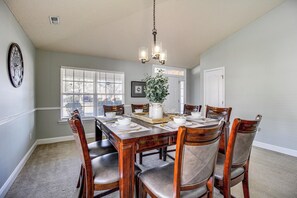 Comedor con una mesa de madera dispuesta para seis personas, rodeada de seis sillas.
