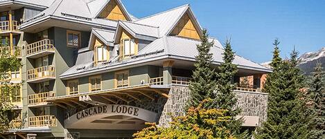 Un edificio de varios pisos con fachada de piedra y un letrero que dice "Cascade Lodge".