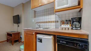 Une petite cuisine équipée d’un four à micro-ondes, d’une machine à café et d’un lave-vaisselle.