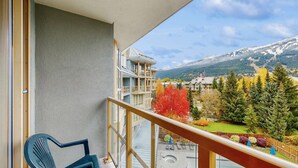 Ein Balkon mit Blick auf einen Berg und Herbstlaub.