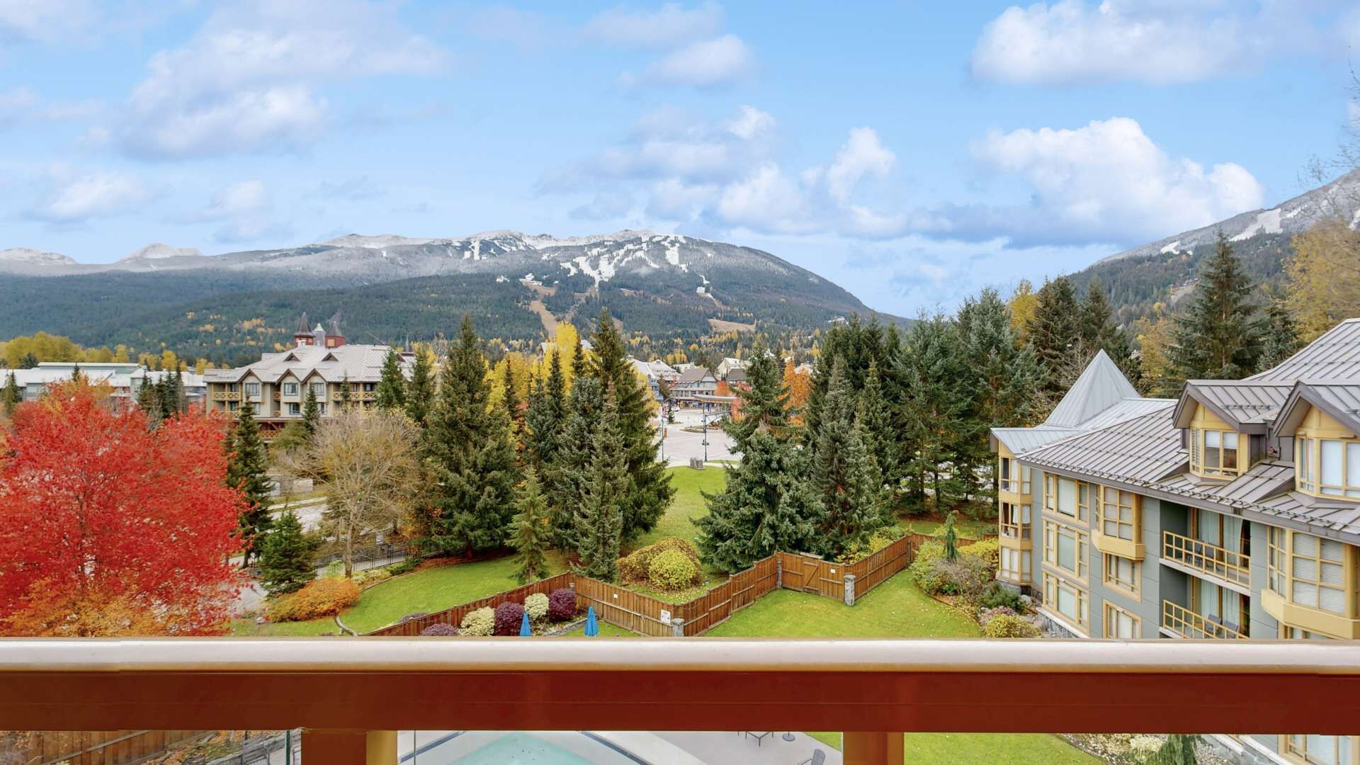 Une ville de montagne offrant une vue sur des sommets enneigés, des immeubles résidentiels et un espace piscine.