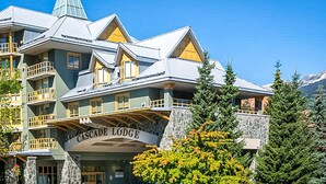Ein mehrstöckiges Gebäude mit Balkonen und einer Stein-Fassade, mit der Aufschrift 'Cascade Lodge'.