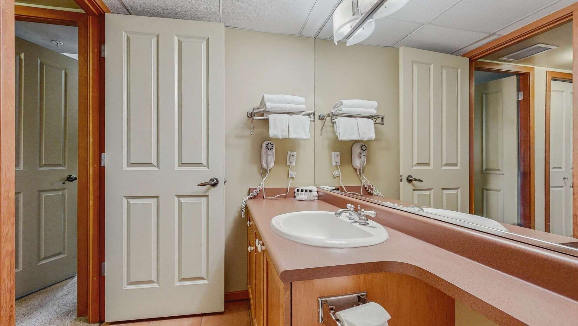 A bathroom with a sink, two towel racks, and a mirror.