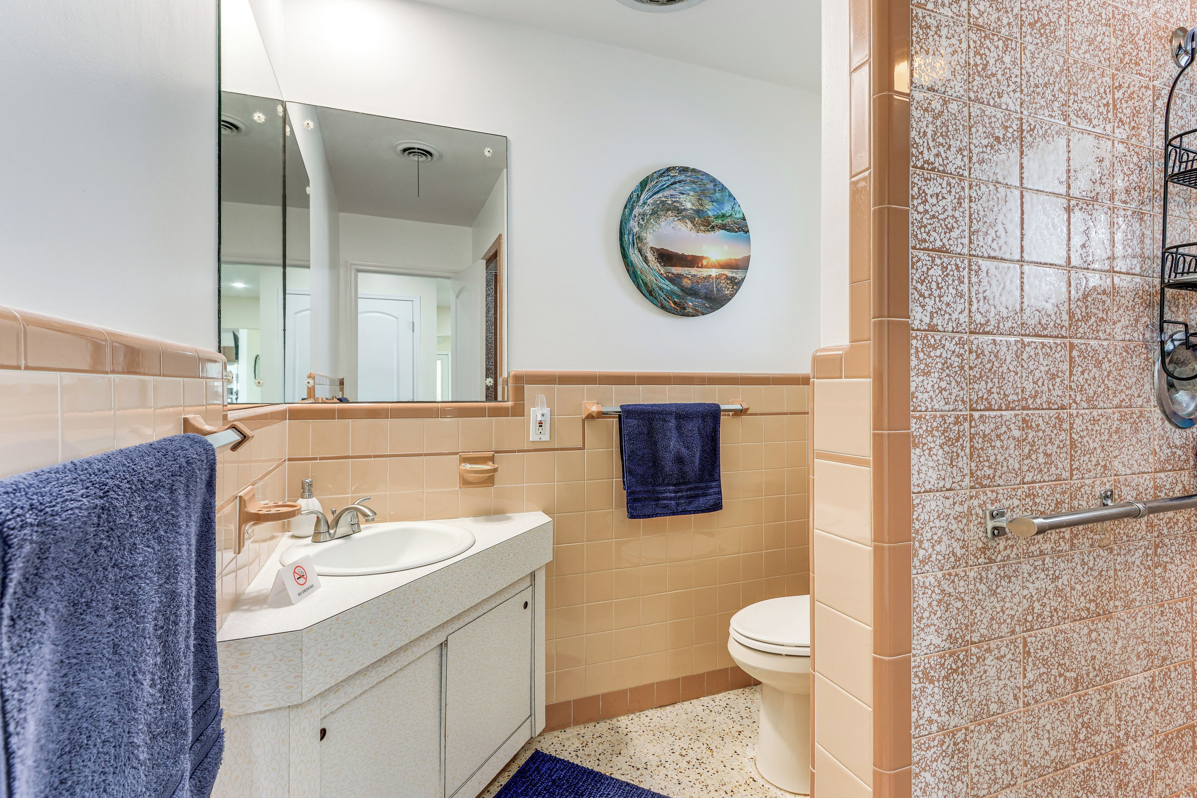 Une salle de bain avec un double lavabo, des toilettes, un porte-serviettes et un miroir.