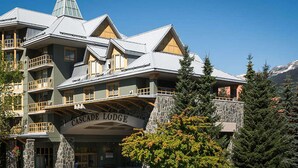 Un immeuble à plusieurs étages, doté de balcons et d’une façade en pierre, portant l’inscription « Cascade Lodge ».