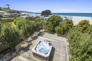 A hot tub on a wooden deck with a view of the ocean and hills. - Achilles (Apollo Bay)
