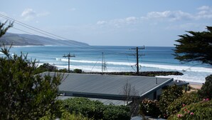 A coastal view with a house in the foreground, a beach, and the ocean. - Achilles (Apollo Bay)