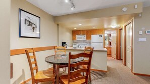 A compact kitchen with wooden cabinets, a microwave, a stove, and a refrigerator.