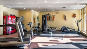 Une salle de sport équipée de machines de cardio, de matériel de musculation et dotée d’une grande fenêtre laissant entrer la lumière naturelle.