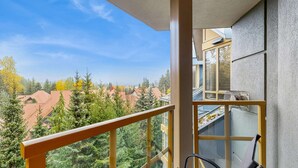 Ein Balkon mit Blick auf eine Wohngegend, mit Häusern und Bäumen.
