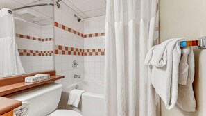 Une salle de bain avec douche, toilettes et lavabo.