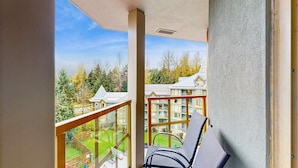 Un balcon donnant sur un quartier résidentiel, avec vue sur des maisons et des arbres.