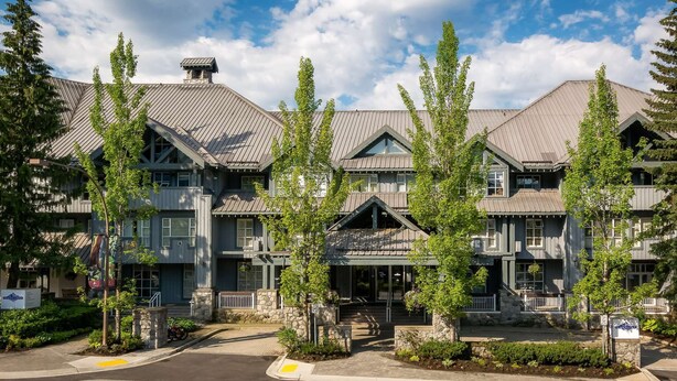 A multi-story hotel with a traditional architectural style, featuring stone foundations and a symmetrical facade. - Whistler - Glacier Lodge 232 (Whistler)