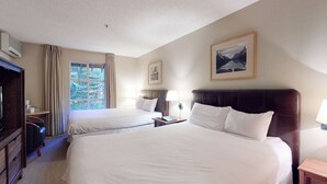 A hotel room with two beds, a desk, a chair, a TV, and a window with curtains. - Whistler - Glacier Lodge 232 (Whistler)