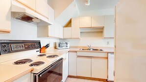 A compact kitchen with a stove, microwave, sink, and dishwasher. - Whistler - Glacier Lodge 303 (Whistler)