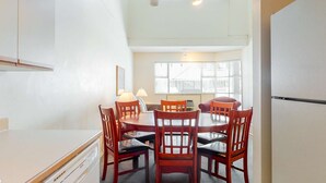 A compact kitchen with a dining area, a refrigerator, and a window with blinds. - Whistler - Glacier Lodge 303 (Whistler)