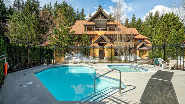 Ein Resort mit großzügigem Poolbereich, zahlreichen Liegestühlen und einem Gebäude mit markanter Architektur.