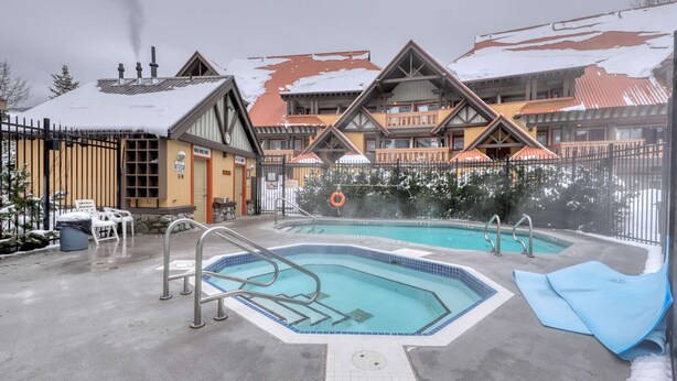 Ein Poolbereich mit zwei Pools, einem Rettungsring und einer überdachten Sitzgelegenheit.