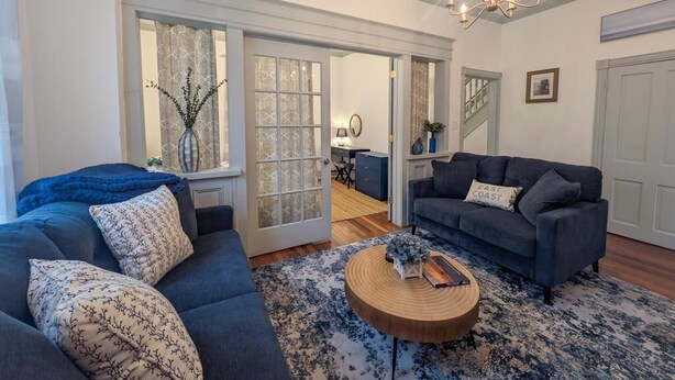 Een woonkamer met een bank, een salontafel en een kroonluchter.
