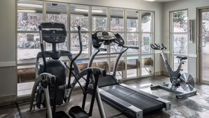 Ein Fitnessraum mit Laufbändern, Crosstrainern und einem Ergometer.