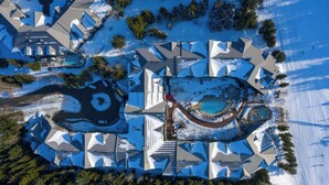 An aerial view of a residential area with multiple houses, a swimming pool, and a circular water feature. - Whistler - The Aspens 263 (Whistler)