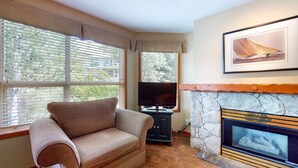 Una sala acogedora con chimenea, televisor y un sofá cómodo.