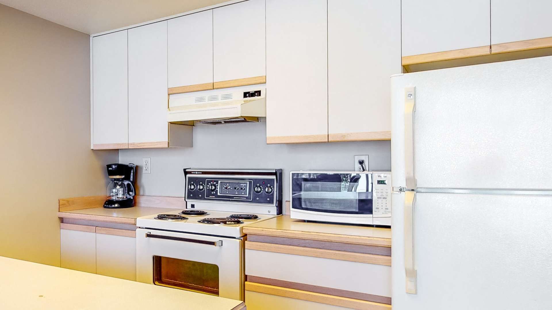 Cocina compacta con estufa, microondas y refrigerador.