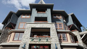 Ein mehrstöckiges Gebäude mit einer Stein-Fassade, großen Fenstern und einem Schild für Eagle Lodge Caramba Restaurante.