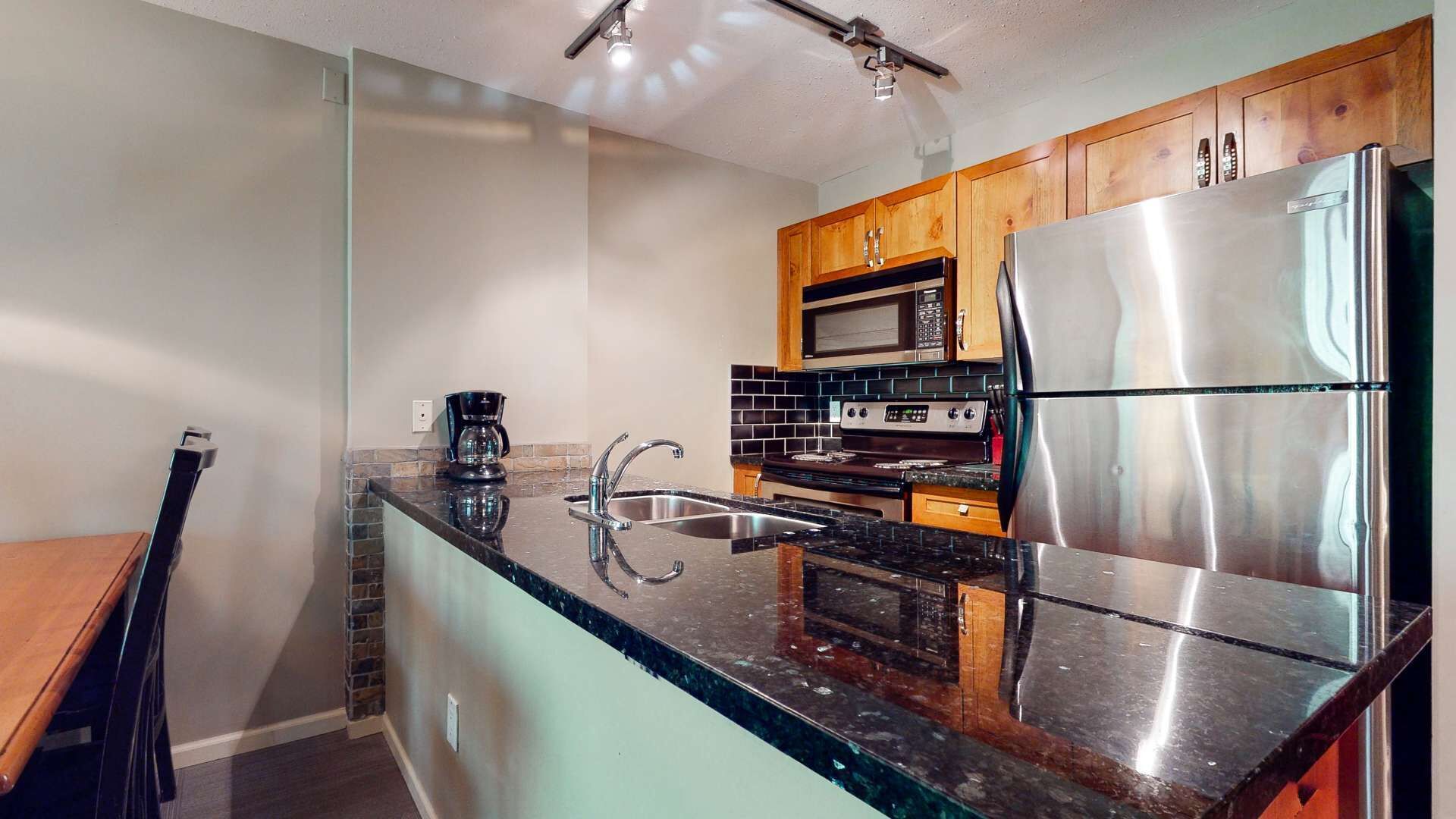 A modern kitchen with a stainless steel refrigerator, a microwave, and a stove.