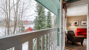 A room with a view of a snowy landscape, a red building, and a green door. - Whistler - Town Plaza 302 (Whistler)