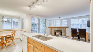 Una cocina moderna con una isla grande, lavavajillas integrado y una chimenea.