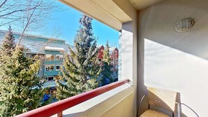 Un balcone con vista su edifici e alberi.