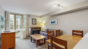 Una sala de estar moderna con chimenea, sofá, mesa de comedor y sillas.