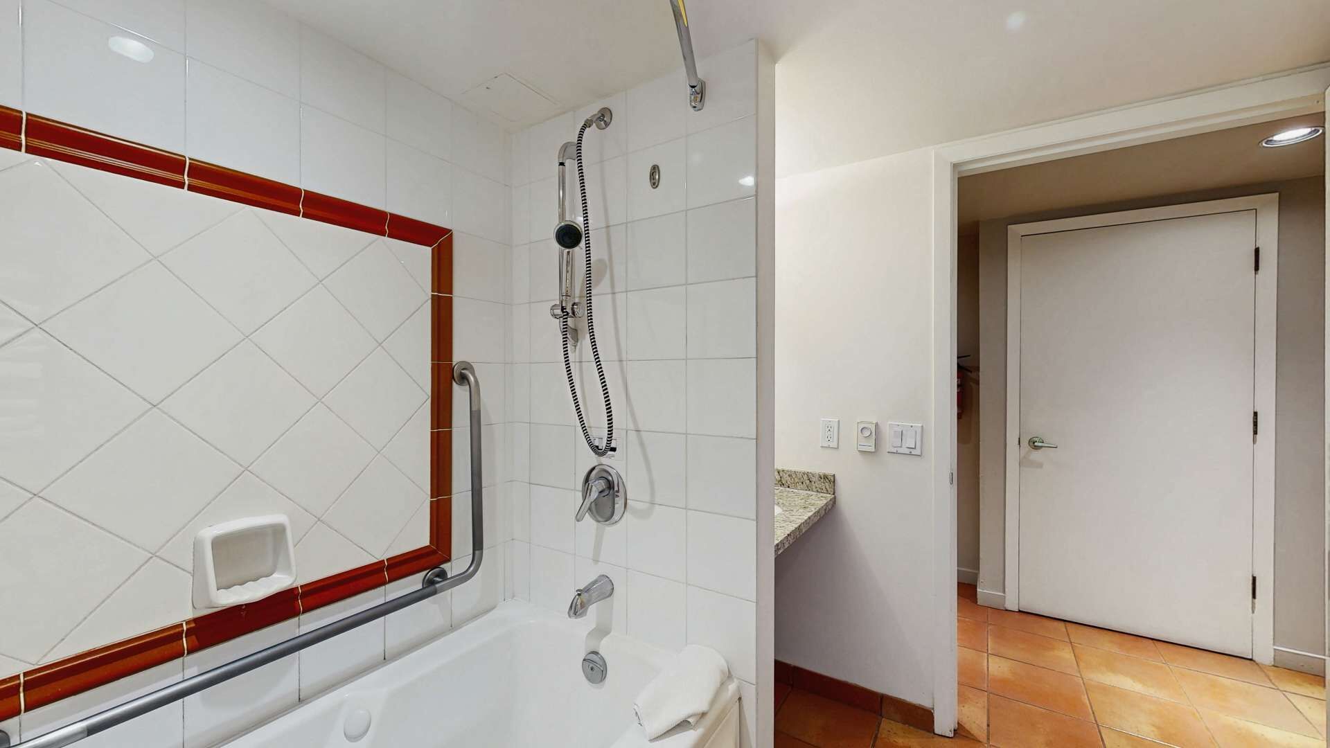 A bathroom with a shower, toilet, and a sink with a marble countertop.