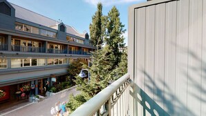 Un hotel de varios pisos con balcones y un telesilla visible en el patio.