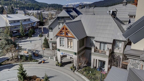 Un hotel con una entrada destacada, un balcón y vistas del entorno.