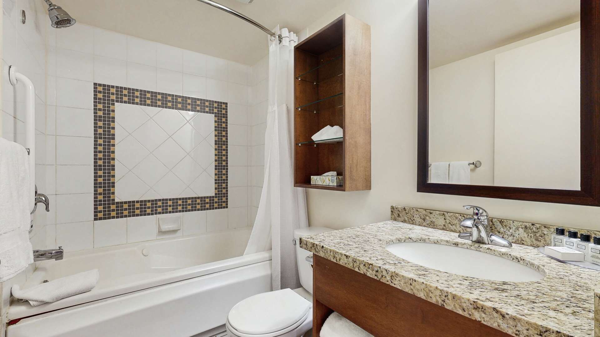 A bathroom with a shower, toilet, and sink area.