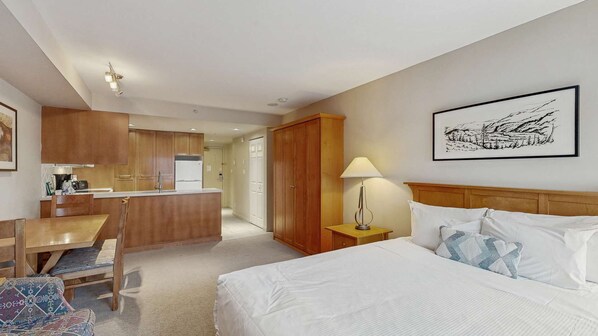 Une chambre d’hôtel avec un lit, une table de chevet, une lampe et un tableau au mur.