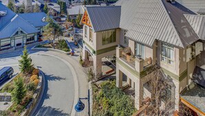 Un edificio de varios pisos con un balcón, una entrada curva y vistas a la calle.