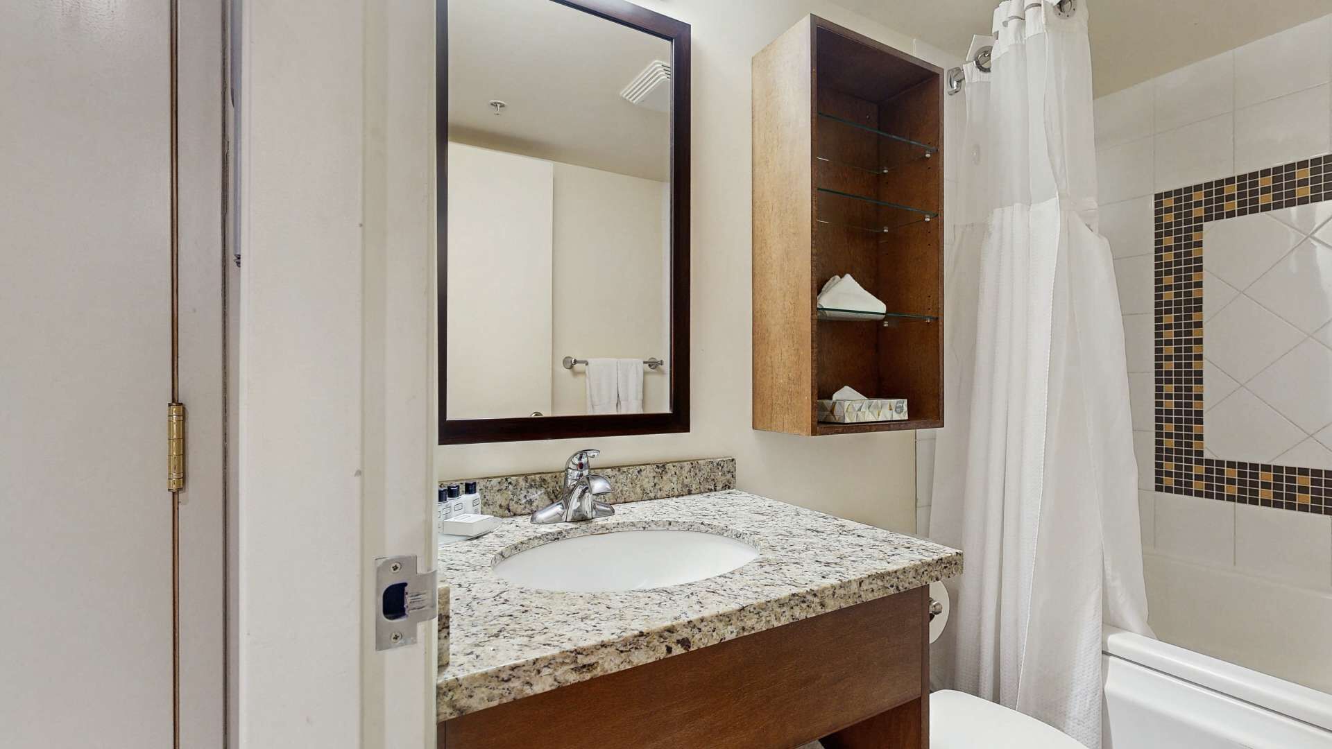 A bathroom with a sink, mirror, and a shower curtain.