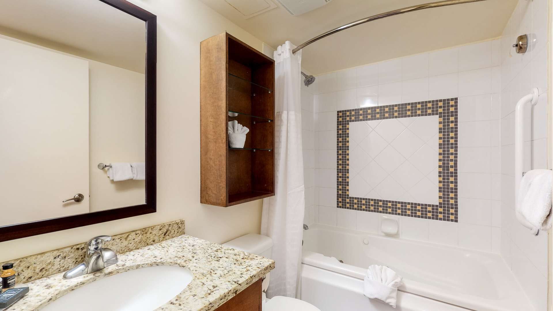 Un baño con lavamanos, espejo, ducha y perchero.