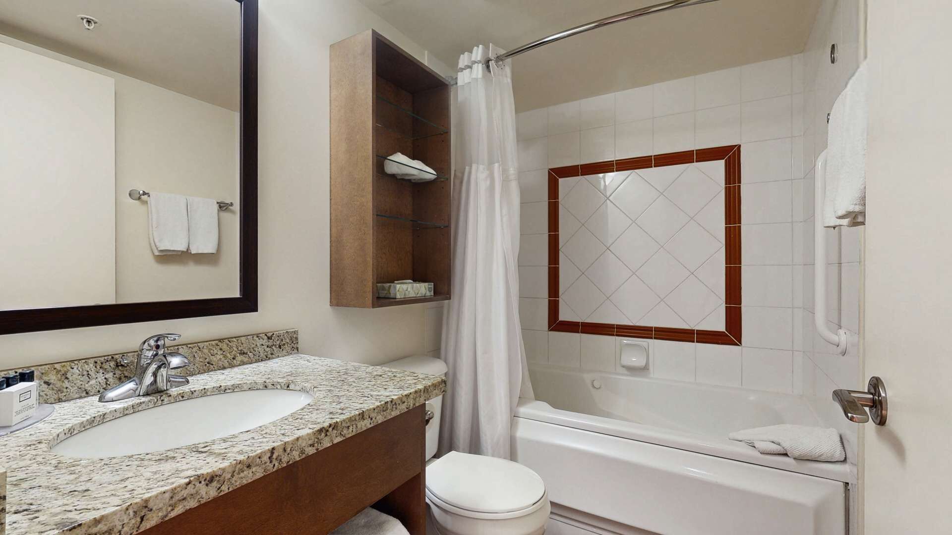 Ein Badezimmer mit Marmorwaschtisch, Toilette, Badewanne und Duschvorhang.
