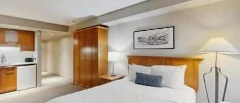 Ein Hotelzimmer mit einem Bett, einem Schreibtisch und einer Küchenzeile.
