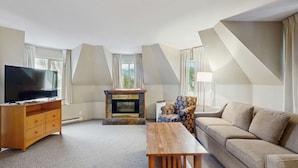 Una sala de estar moderna con un televisor de pantalla plana, chimenea, sofá y mesa de comedor.