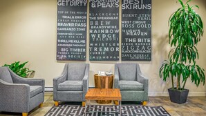 A room with grey armchairs, a wooden coffee table, and a potted plant. - Whistler - Whistler Peak Lodge 428 (Whistler)