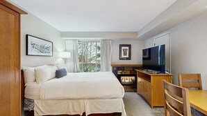 Ein Hotelzimmer mit Bett, Schreibtisch, Fernseher und Kamin.