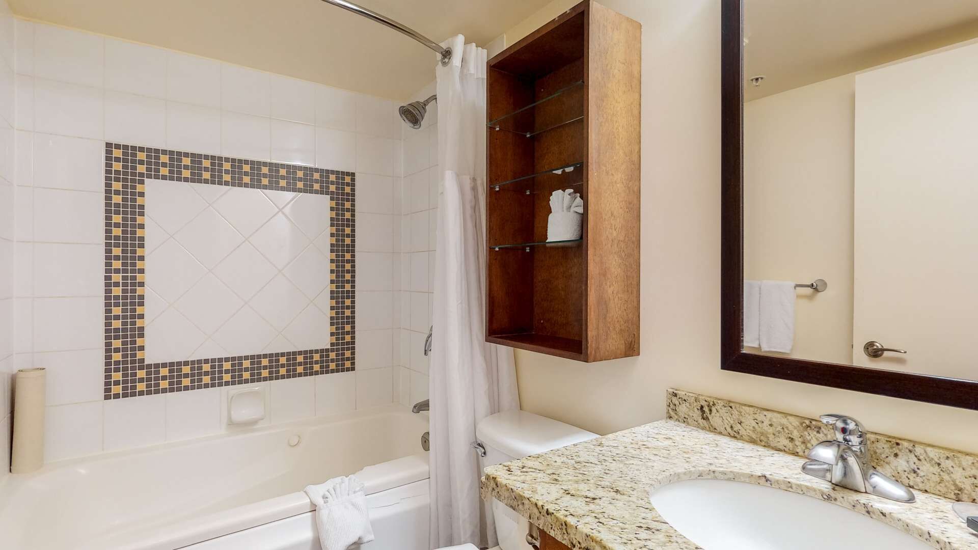 A bathroom with a bathtub, a shower, a sink, and a mirror.