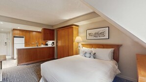 A hotel room with a bed, a desk, a kitchenette, and a painting on the wall. - Whistler - Whistler Peak Lodge 4402 (Whistler)