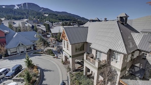 A multi-story building with a sloped roof, a balcony, and a view of a mountain. - Whistler - Whistler Peak Lodge 4402 (Whistler)
