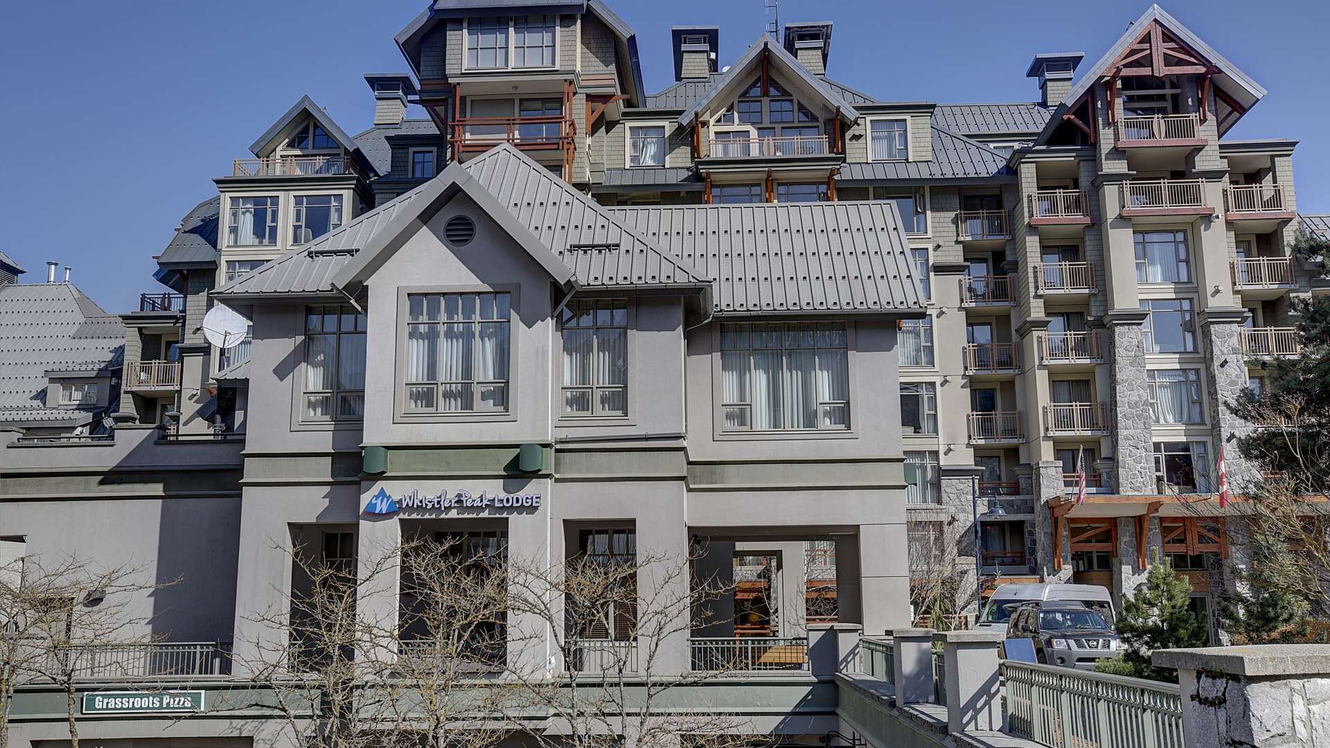 A multi-story building with a ski lodge sign, balconies, and a restaurant sign.